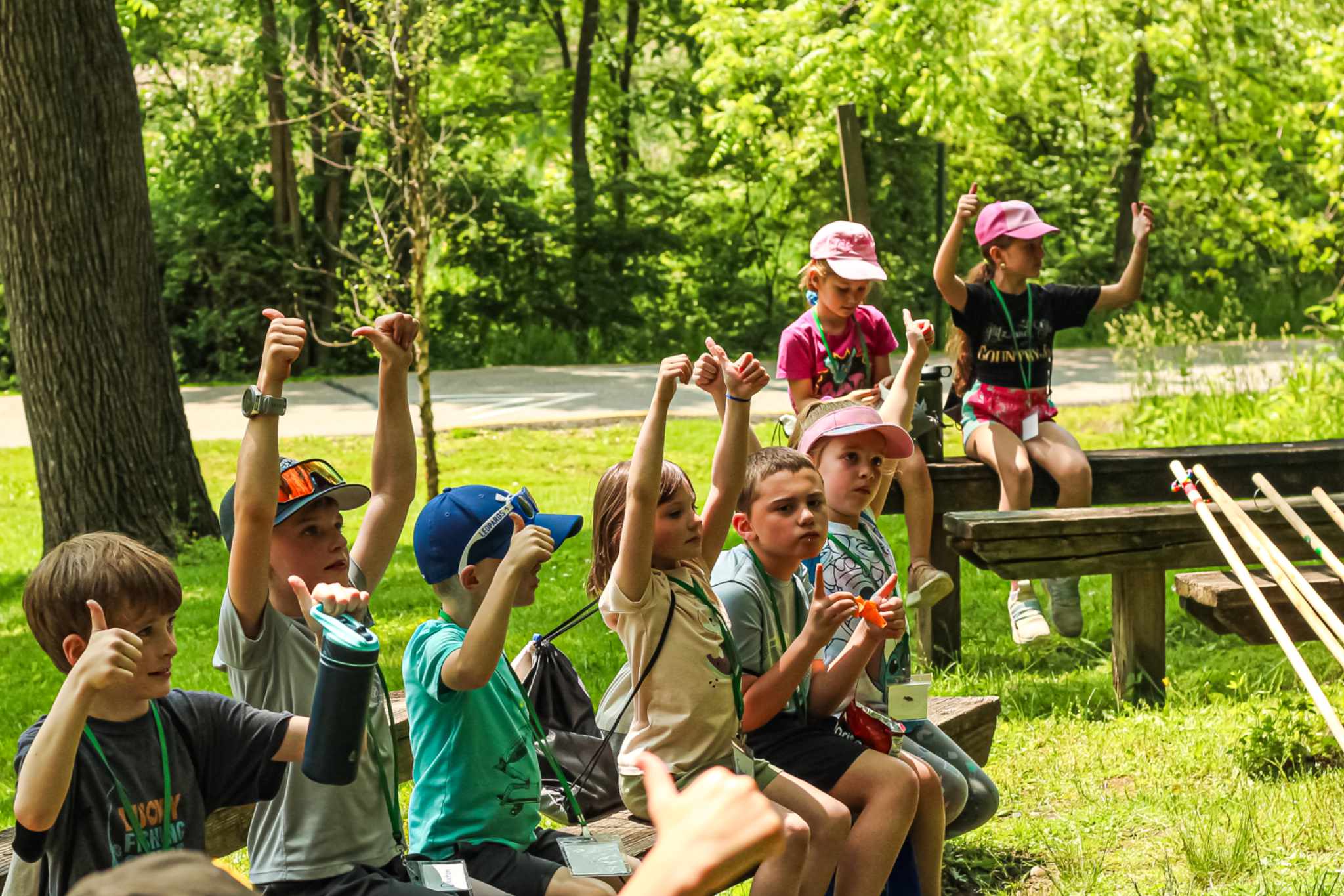Group of kids on bench giving two thumbs up